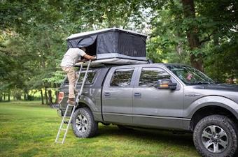 The James Baroud Odyssey on a truck with a man climbing up the ladder